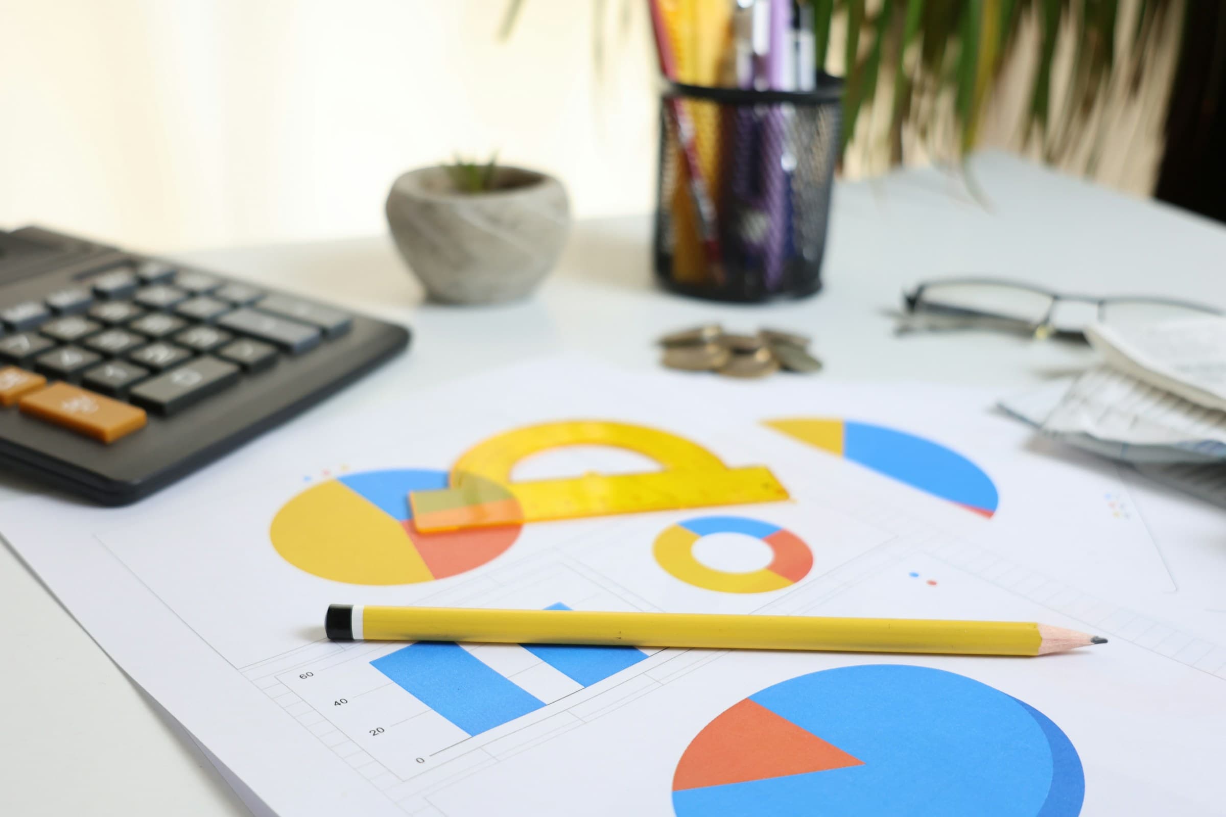 Calculatrice et graphiques sur un bureau pour illustrer l'analyse de rendement locatif