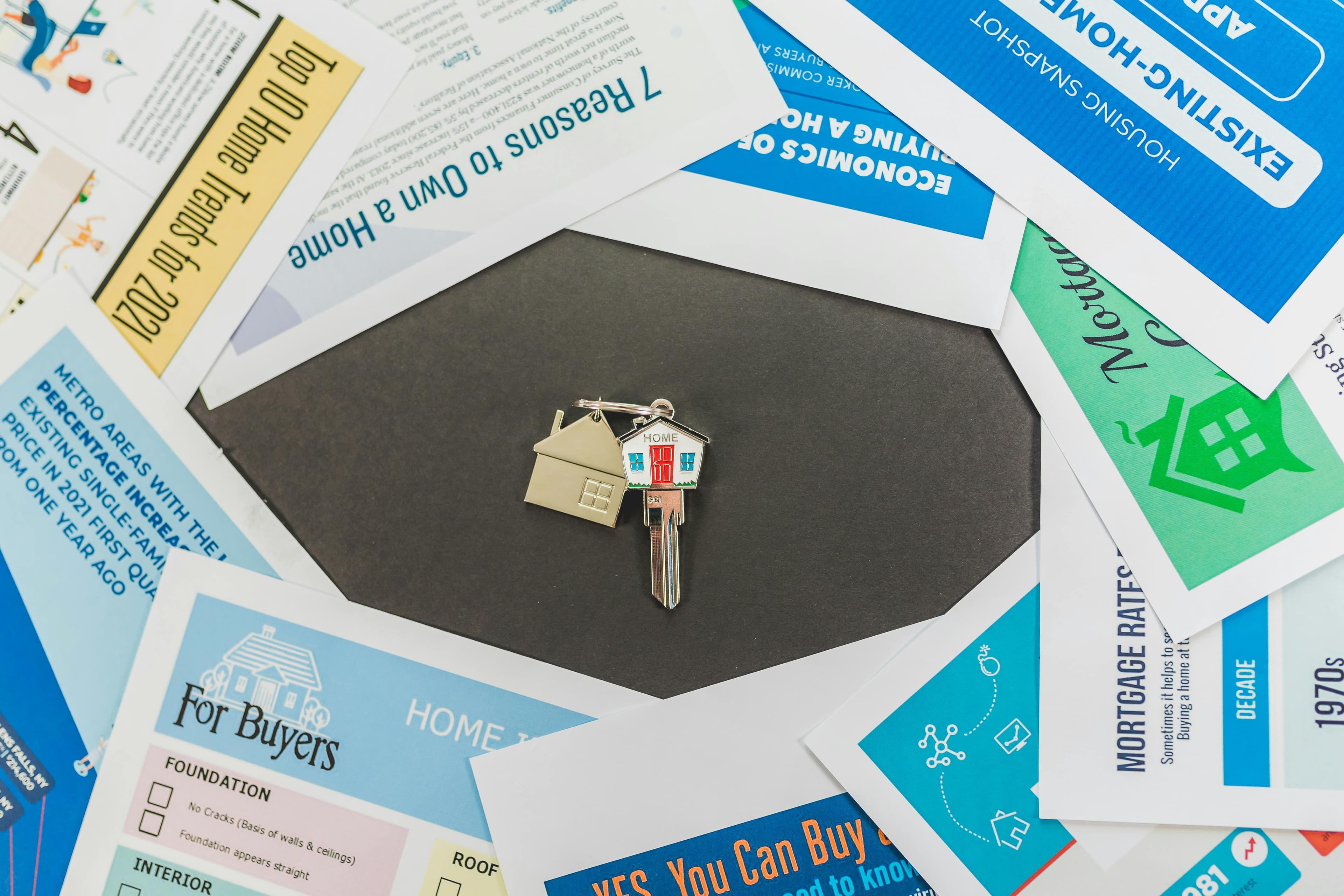 Top-down view of a house key resting on real estate documents, illustrating a rental investment guide for Quebec